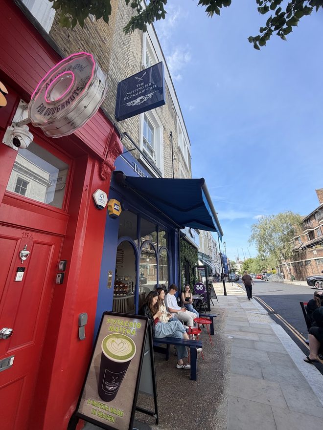 Street view of the café frontage with its red door and blue awning